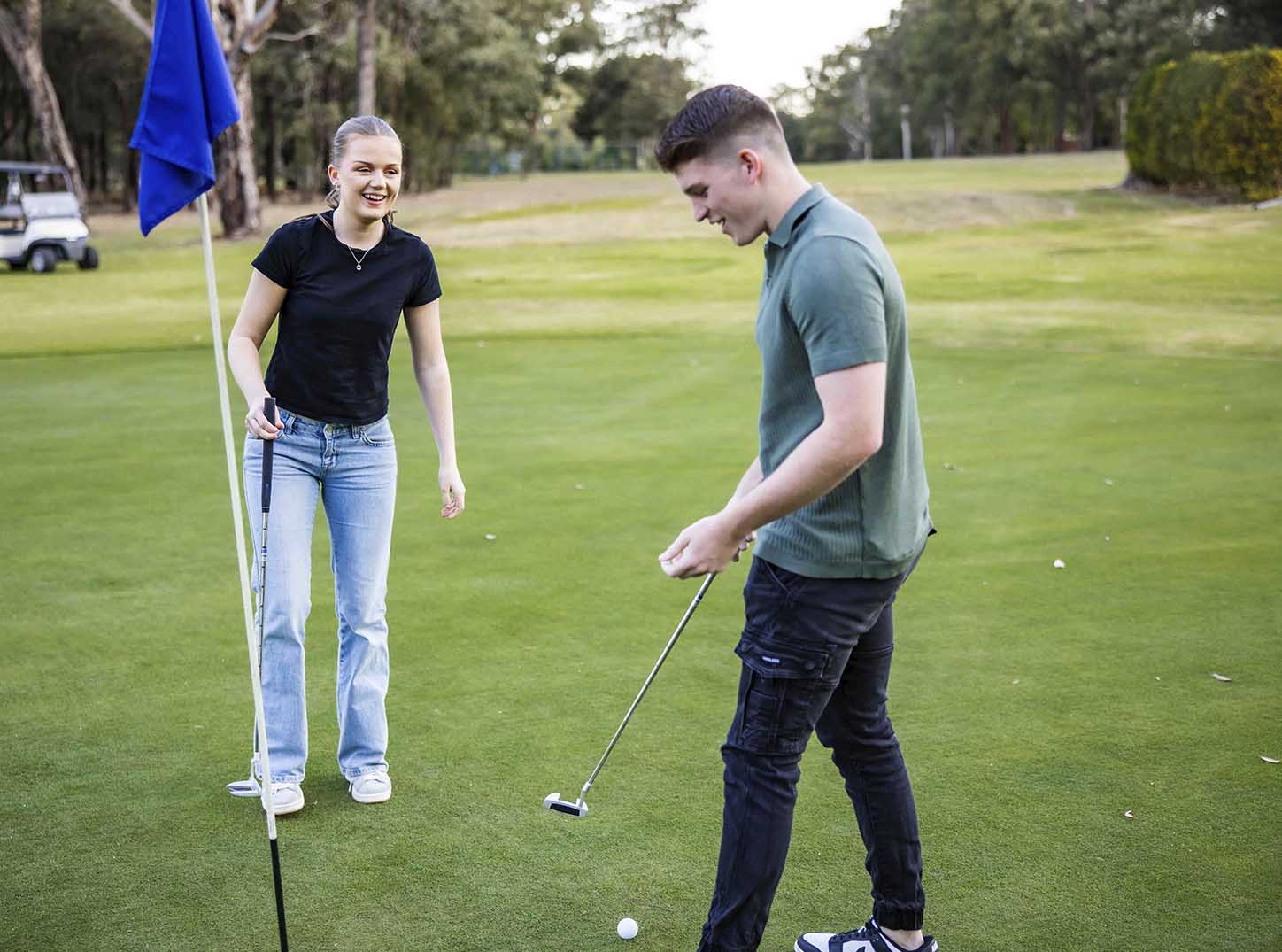 2 Friends playing golf at Leonay Golf Club Golf Course with a golf buggy and trees in the background