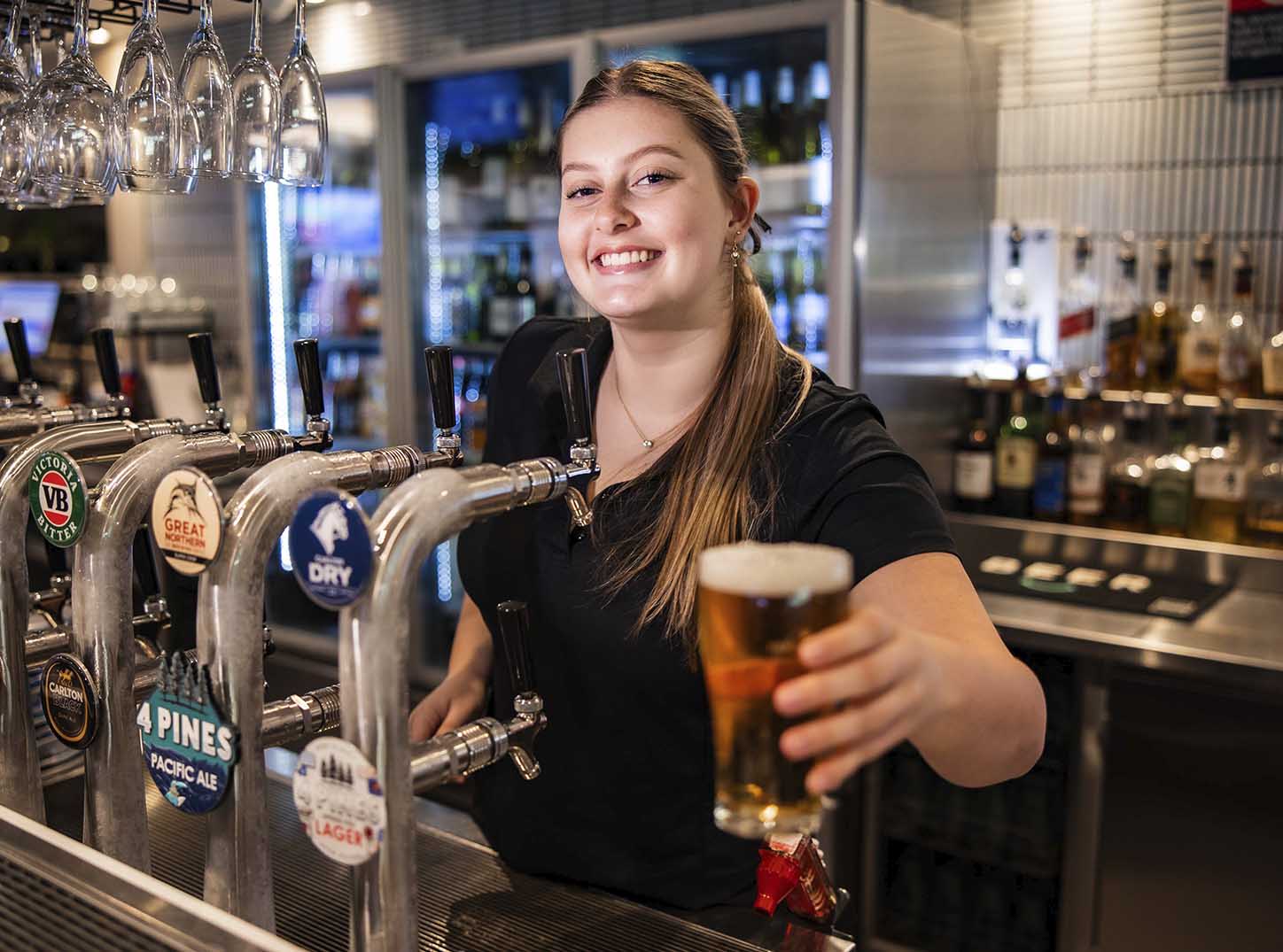 Smiling bar staff serving a beer at Leonay Golf Club