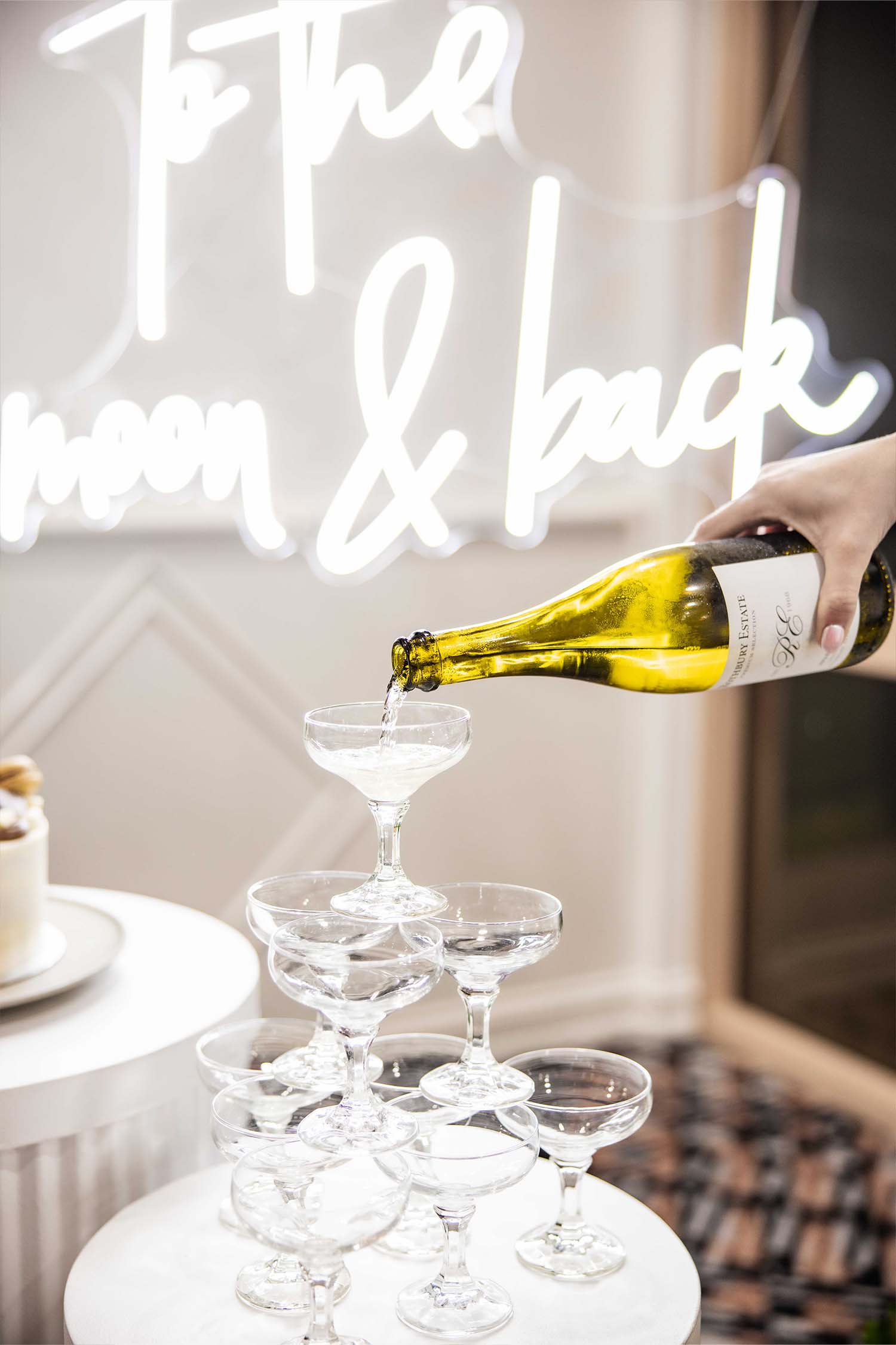 Champagne being poured into a champagne tower in the Functions room at Leonay Golf Club with wedding decorations set up